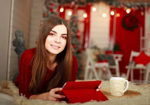 Mujer acostada en la cama con la tableta en el fondo de la Navidad — Foto de Stock