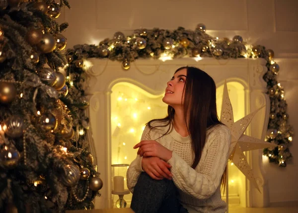 Mujer soñadora cerca del árbol de Navidad con luces decorando —  Fotos de Stock