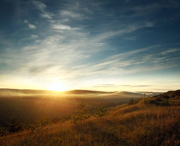 Hemel in de stralen van de zon op de heuvels en velden instellen — Stockfoto