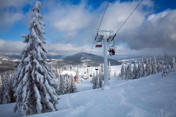 Skilift in besneeuwde winterlandschap in bergen van vuren bos — Stockfoto