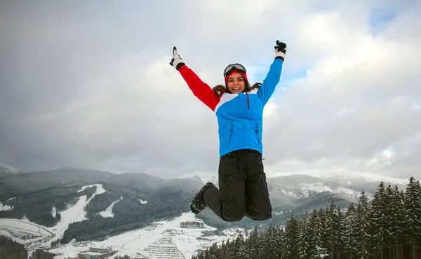 Mulher de salto feliz no inverno na estância de esqui — Fotografia de Stock