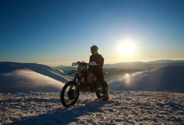 Extremo motociclista em moto esporte no inverno montanha de neve no céu — Fotografia de Stock