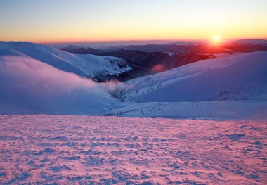 Karlı kış dağlar gökyüzü arka plan üzerinde üstüne günbatımı
