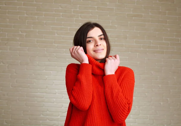 Vrolijke jonge vrouw in rode trui thuis in studio — Stockfoto