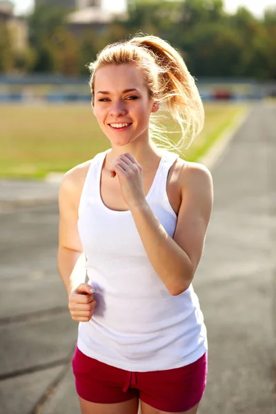 Glad jente jogger på idrettsstadion sunn livsstil utendørs – stockfoto