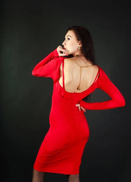 Motedame i rød kjole på svart bakgrunn i studio – stockfoto