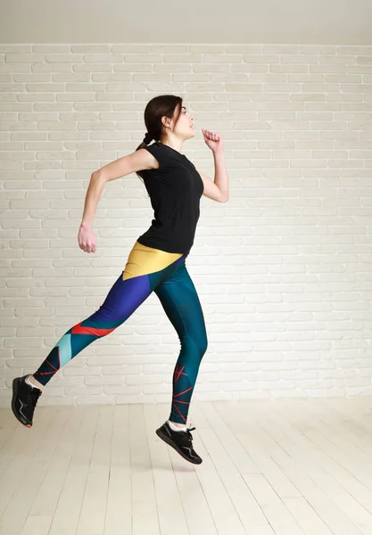 Hoppande kvinna gör fitnessövningar i studio — Stockfoto