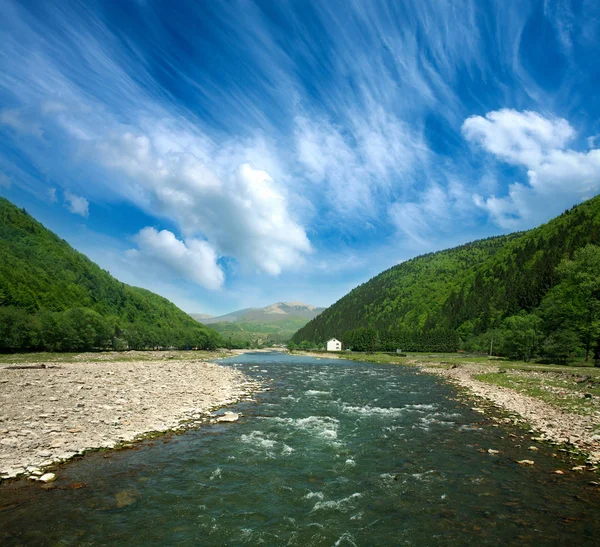 Stroom van de rivier tussen de bergen van het bos op dramatische hemel — Stockfoto