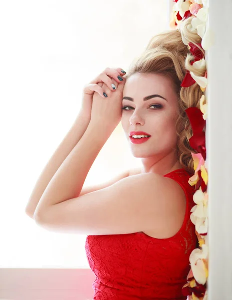 Красива модна жінка в пелюстках червоної троянди на білому — стокове фото