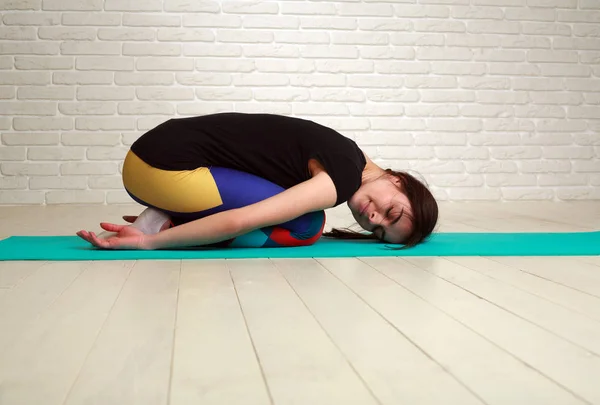 Vrouw doen yoga en fitness oefeningen haar lichaam uitrekken — Stockfoto