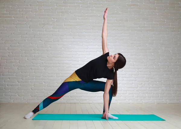 Kvinnan gör yoga och fitness övningar stretching hennes kropp — Stockfoto