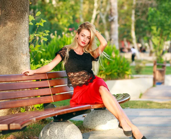 Beautiful dreamy woman on bench in city park in summer — Stock Photo, Image