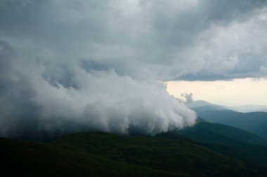 Gri fırtına rüzgarlı bulutlarda dağlar