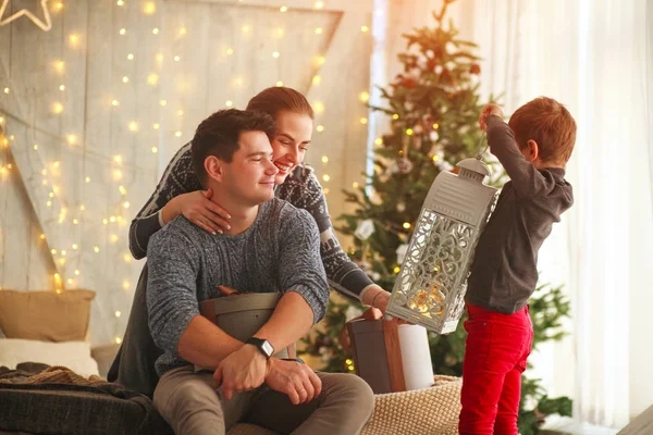 Молодая семья родителей с сыном в Новый год дарить подарки на дому — стоковое фото