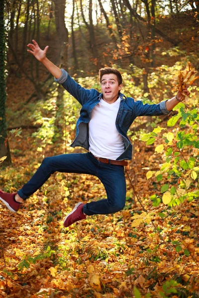Молодий смішний і цікавий красивий чоловік стрибає в лісовому парку — стокове фото