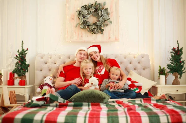 Радостная молодая семья дома на Рождество в постели с Новым годом — стоковое фото