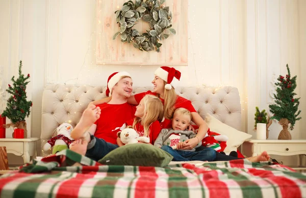 Радостная молодая семья дома на Рождество в постели с Новым годом — стоковое фото