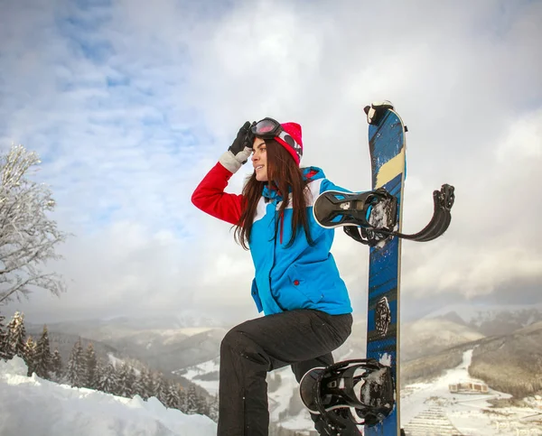 Junge Frau mit Snowboard hoch oben in den Winterbergen — Stockfoto