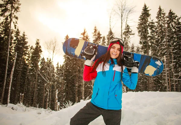 Молода жінка зі сноубордом високо в зимових горах сходження — стокове фото