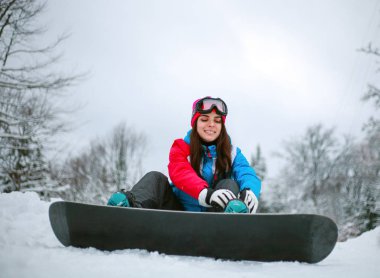 Kış dağlarında snowboard yapan genç bir kadın, ekstrem spor