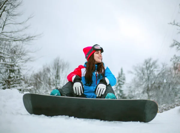 Молода жінка в зимових горах зі сноубордом, екстремальний спорт — стокове фото