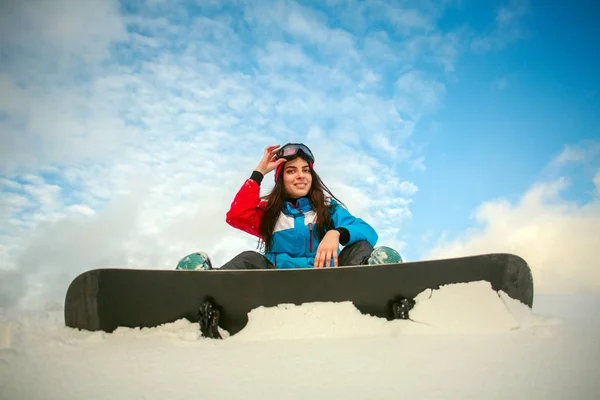 Mujer joven en las montañas de invierno con snowboard, deporte extremo —  Fotos de Stock