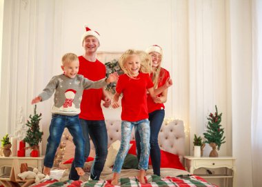 Mutlu genç aile atlama ve Noel 'de evde yatakta eğlence