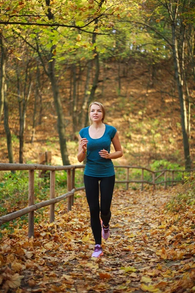 Młoda szczupła kobieta biegnie w parku leśnym, zdrowy styl życia — Zdjęcie stockowe