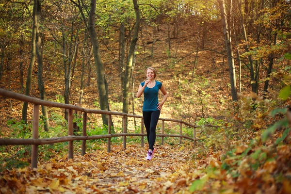 Młoda szczupła kobieta biegnie w parku leśnym, zdrowy styl życia — Zdjęcie stockowe