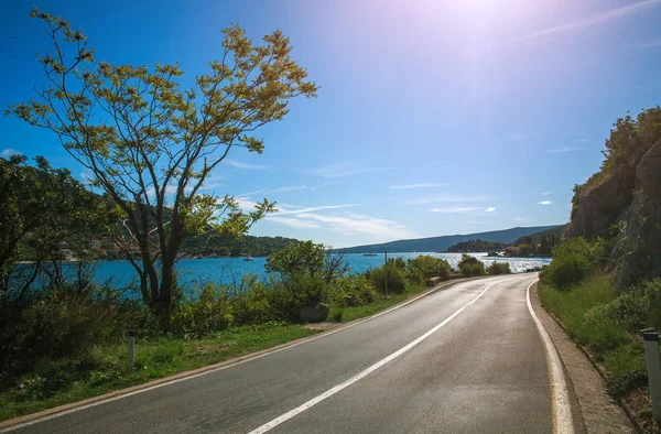 Asphalt road along sea bay and mountains on blue sky, Europe — Stock Photo, Image