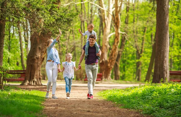 Yeşil bir yaz parkında çocuklu mutlu bir aile babası. Birlikte yürürken iyi eğlenceler.