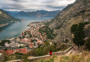 Kotor Körfezi 'ndeki antik taş kalenin, dağların ve gökyüzünün üst manzarası.