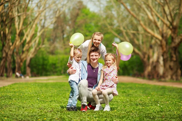 Güneşli Bir Yaz Parkında Mutlu Bir Aile Çimenlerde Birlikte Eğleniyor — Stok fotoğraf
