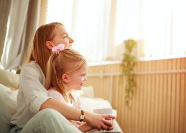 Çocuğu olan genç bir anne yatak odasında eğleniyor, rahat bir hayat sürüyor.