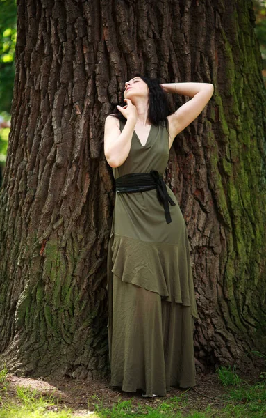 Молодая Женщина Зеленом Платье Медитативно Расслабляется Большого Дерева Лесном Парке — стоковое фото
