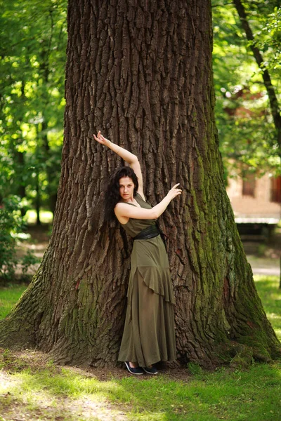 Młoda Kobieta Zielonej Sukience Medytacyjnie Relaksuje Się Pobliżu Dużego Drzewa — Zdjęcie stockowe