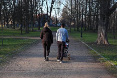 Bahar, güneşin ilk ışıkları, parkta bir aile yürüyüşü, rahatlama. ...