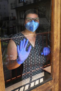 Evinin penceresinde yaşlı bir kadın, bir salgın. ... 