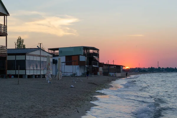 Gecekondu kampı ile deniz kıyısında gün doğumu