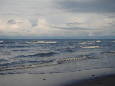 Riga Körfezi sonbaharda. Kumlu sahilde sıçramasına dalgalar.