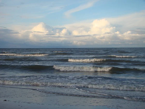 Riga Körfezi sonbaharda. Kumlu sahilde sıçramasına dalgalar.