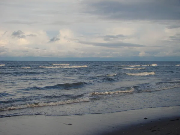 Riga Körfezi sonbaharda. Kumlu sahilde sıçramasına dalgalar.