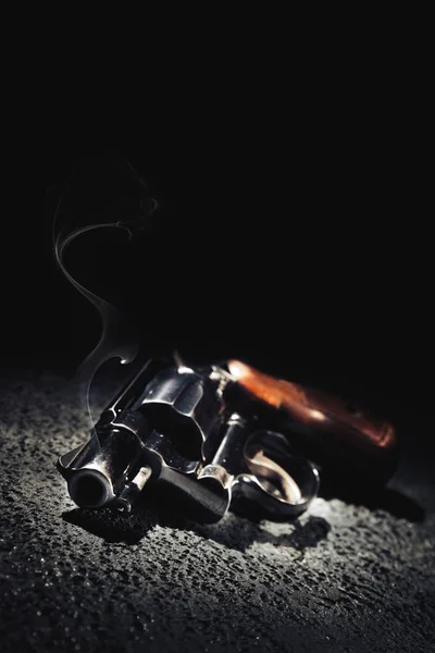 Pistolet z dymu na podłodze, obraz o wysokim kontraście — Zdjęcie stockowe