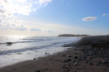 Stoney beach ile okyanus ve coudy gökyüzü