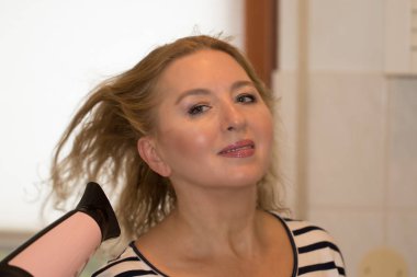 Uzun sarı saçlı güzel kadın saçları bir haird ile kurur