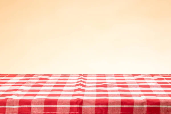 Una mesa vacía con un mantel a cuadros rojo y un bac brillante —  Fotos de Stock