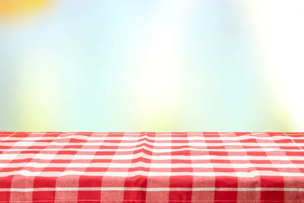 Una mesa vacía con un mantel a cuadros rojo y un col pastel —  Fotos de Stock