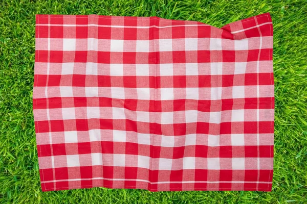 Piknik geçmişi. Bulanık güneşte kırmızı kareli piknik elbisesi.