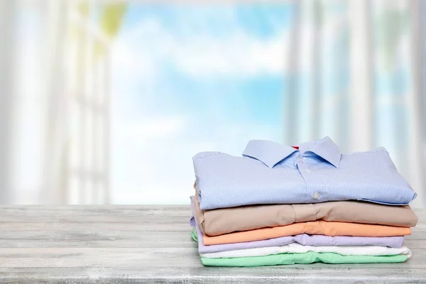 Stack színes ruhákat. Egy halom hajtogatott pamut ing egy fényes — Stock Fotó