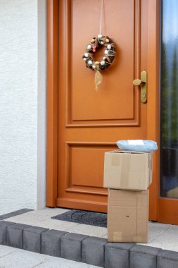 Coronavirus karantina konsepti. Salgın sırasında evin kapısına konmuş üç paketin sorumsuz teslimat servisi. Evde kal ve sosyal ilişkilerden ve mesafelerden uzak dur..